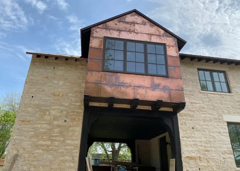 Copper metal panel facade on a stone building for Roof Repair in Rossford